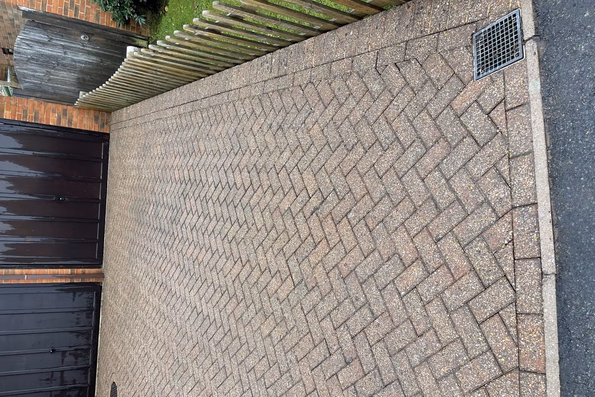The same courtyard after jet washing and re-sanding, the herringbone pattern sharp again and the brick colour separating from the charcoal blocks