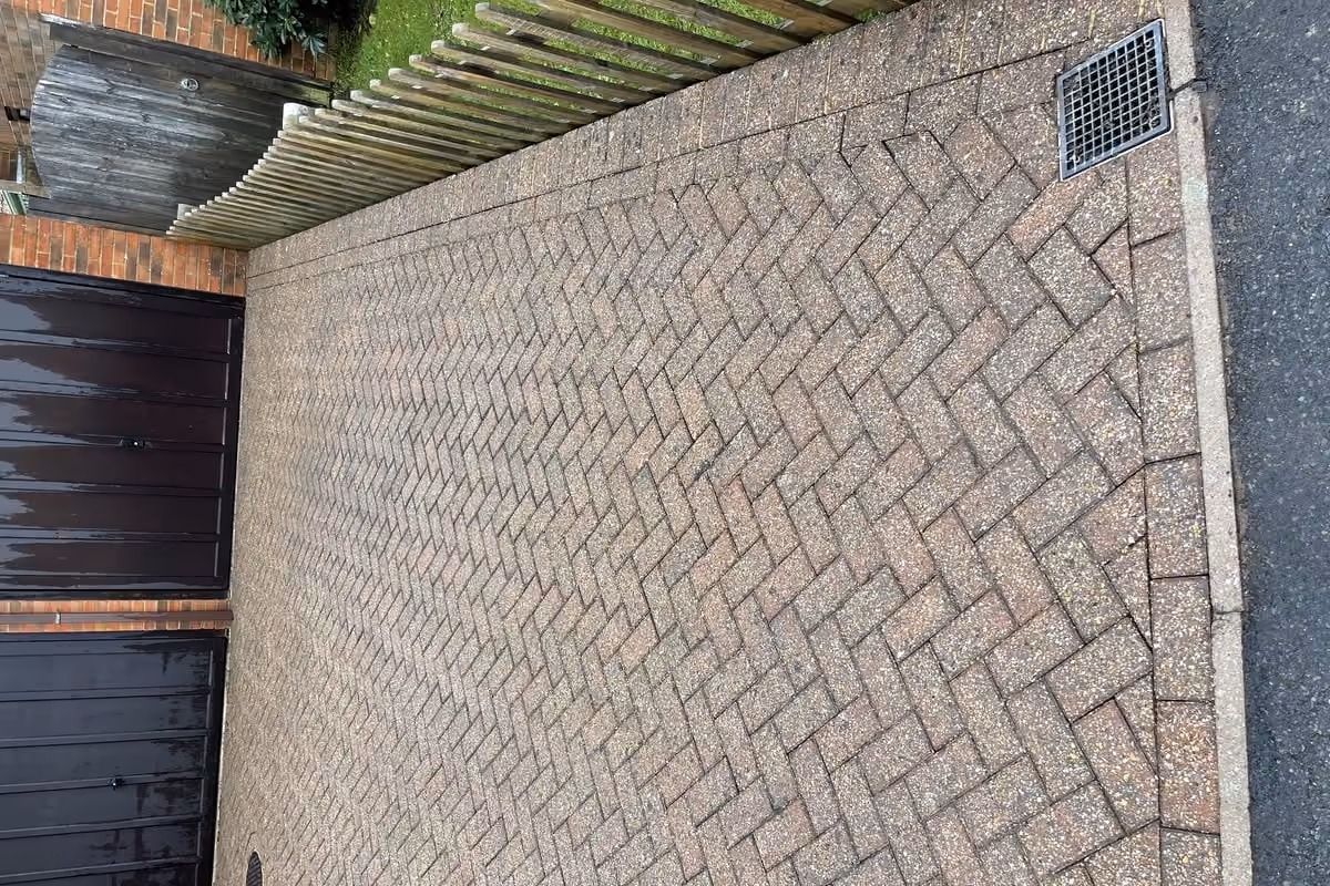 The same courtyard after jet washing and re-sanding, the herringbone pattern sharp again and the brick colour separating from the charcoal blocks